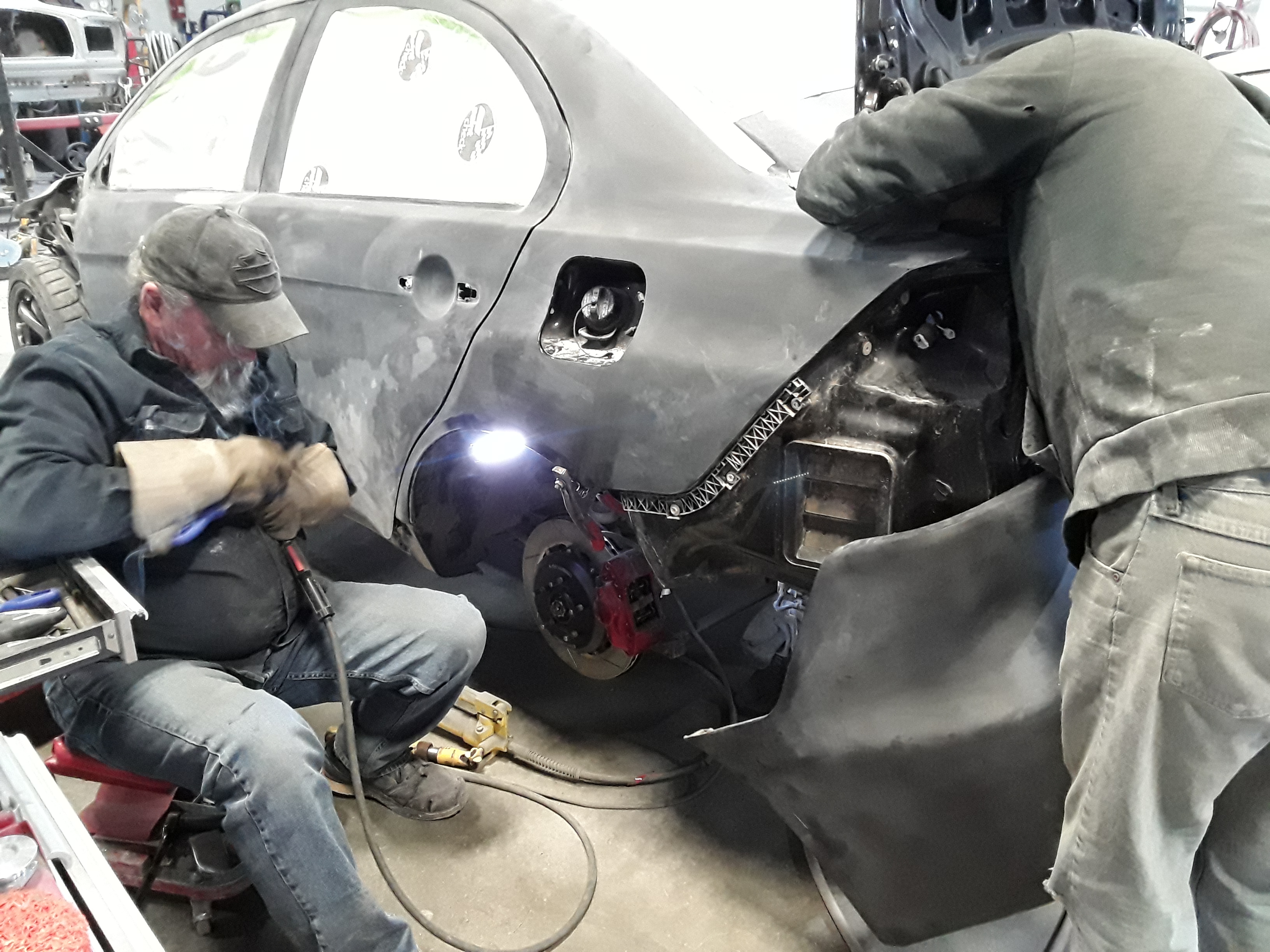 Technicians modifying performance parts to fit Evo X