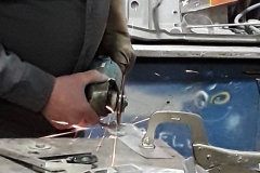 A technician uses a cutting tool to fabricate a metal piece