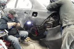 Technicians modifying performance parts to fit Evo X