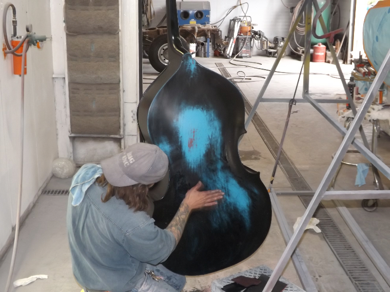 Action shot of the blue bass being painted with distressed effect blue