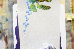 Side one of a snowboard with a certain small cartoon turtle ready to jump into the current